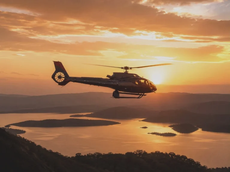 A helicopter banks over a lake and wooded hills at sunrise, the sun low behind a bank of orange cloud